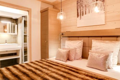 ein Schlafzimmer mit einem Bett und einem Waschbecken in der Unterkunft Résidence Carre Blanc - 5 Pièces pour 8 Personnes 264 in Courchevel