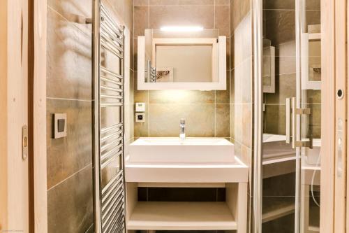 ein Bad mit einem Waschbecken und einem Spiegel in der Unterkunft Résidence Carre Blanc - 5 Pièces pour 8 Personnes 264 in Courchevel
