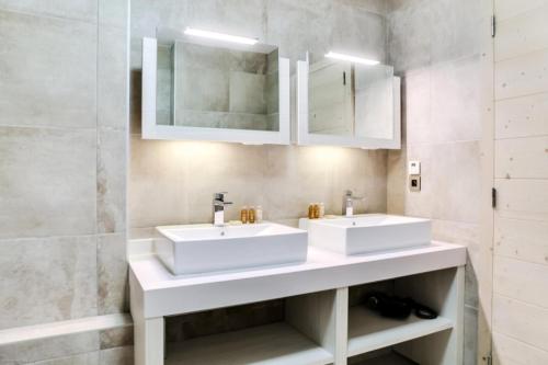 two sinks in a bathroom with white cabinets at Résidence Carre Blanc - 4 Pièces pour 6 Personnes 294 in Courchevel