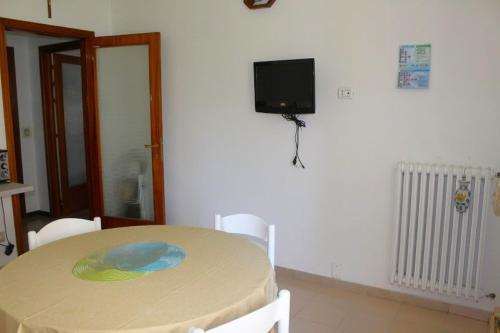 een kamer met een tafel en een tv aan de muur bij GIAMPIERO ampio appartamento con 4 camere e 2 bagni in Sirolo