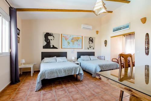 1 dormitorio con 2 camas y mesa. en Apartamento privado con piscina y jardin compartidos., en Valencina de la Concepción