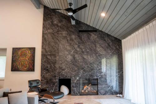 a living room with a fireplace and a ceiling fan at Elkhorn Sun Valley & Dollar Mountain Adventures in Sun Valley