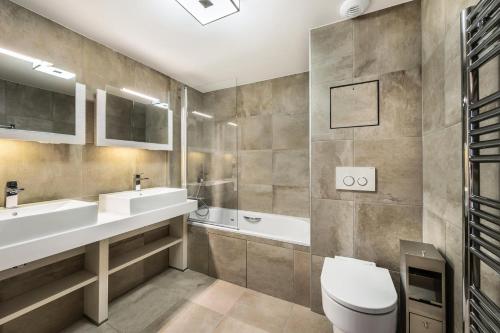 a bathroom with a toilet and a sink and a tub at Résidence Carre Blanc - 5 Pièces pour 8 Personnes 384 in Courchevel