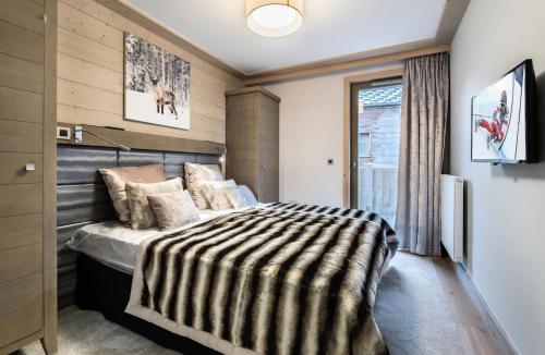 a bedroom with a bed with a striped blanket at Résidence Carre Blanc - 5 Pièces pour 8 Personnes 384 in Courchevel