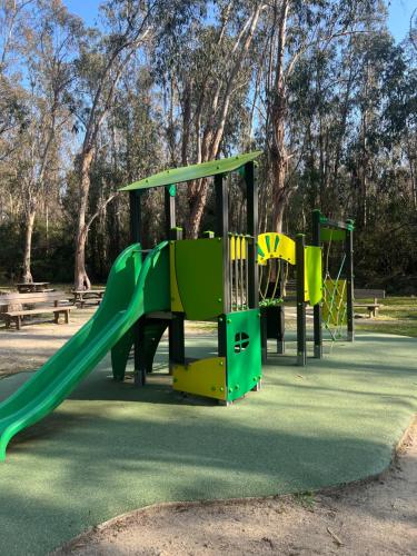 un parque infantil con un tobogán verde en les bungalows de Lisa Maria, en SERRA DI FIUMORBO