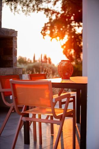 a wooden table with chairs and a lamp on it at 4RosesVillas in Litochoro