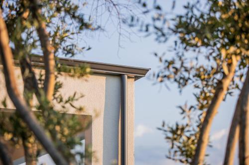 a corner of a building with trees in the background at 4RosesVillas in Litochoro