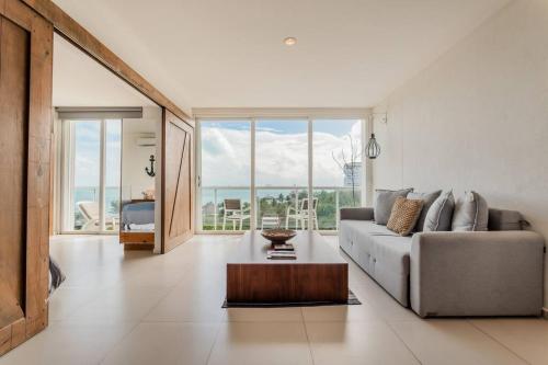 a living room with a couch and a table at *OCEAN Beachfront 4 BDR with pool by Casa Paraiso* in Cancún