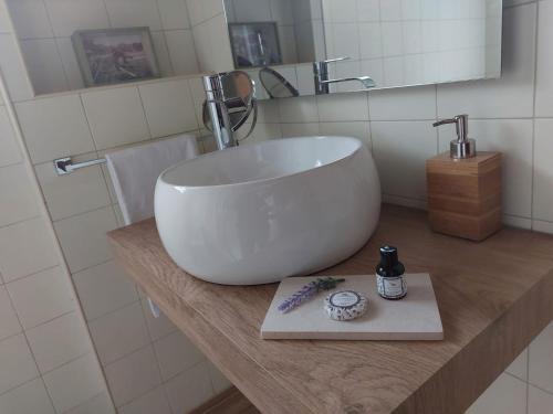 La salle de bains est pourvue d'un grand lavabo blanc sur un comptoir. dans l'établissement Aldeamento Turístico da Companhia das Lezírias, à Samora Correia