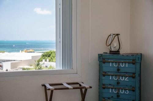 a blue dresser and a window with a view of the ocean at *OCEAN Beachfront 4 BDR with pool by Casa Paraiso* in Cancún