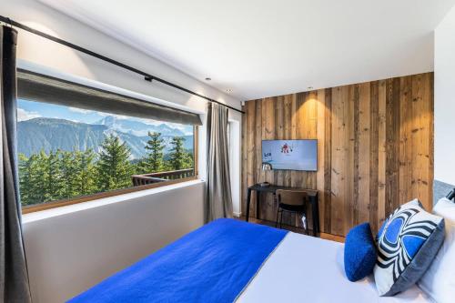 1 dormitorio con cama y ventana grande en Résidence Horizon Blanc - 4 Pièces pour 6 Personnes 314, en Courchevel