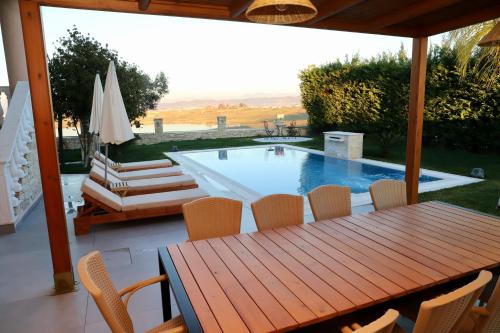 um pátio com uma mesa e cadeiras e uma piscina em Green Villa with Private Pool em Durrës