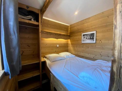 ヴァル・トランスにあるRésidence Vanoise - Val Thorens: appartement entièrement rénové aux pieds des pistes MAE-8924の木製の部屋にベッド1台が備わるベッドルーム1室があります。