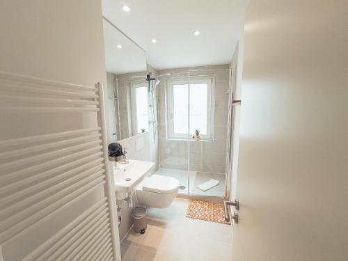 Baño blanco con aseo y lavamanos en RR - NEW - Gorgeous 50qm Apartment - Washer - WIFI, en Rusches Hof