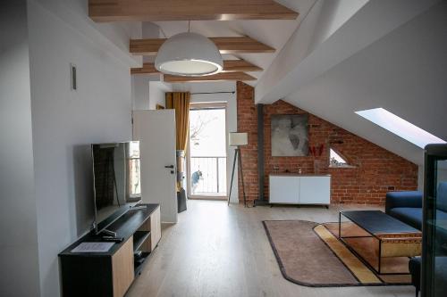 un soggiorno mansardato con parete in mattoni di Senamiescio apartamentai Kaune a Kaunas