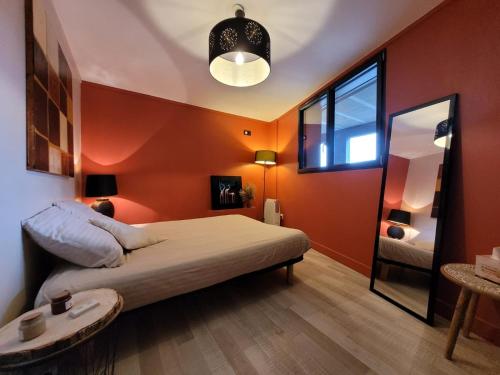 - une chambre avec des murs orange et un lit avec une table dans l'établissement Chambre au coeur de la Maurienne, à Montvernier