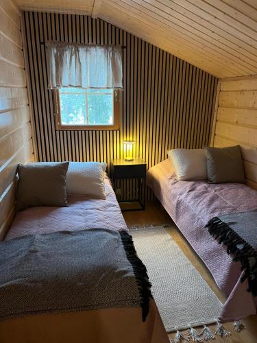 sypialnia z 2 łóżkami i oknem w pokoju w obiekcie Levin Ruska B w mieście Kittilä