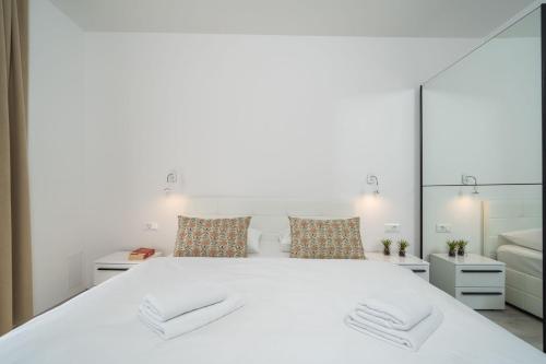 a bedroom with a large white bed with mirrors at The Loft in Mokošica