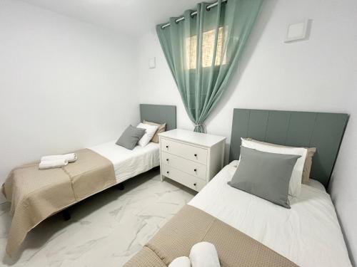 a bedroom with two beds and a window at Jandia Beach Apartment 2 in Morro del Jable