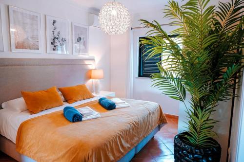 een slaapkamer met een bed met 2 kussens en een palmboom bij Villa Miracampo - Elegant Secret in Albufeira