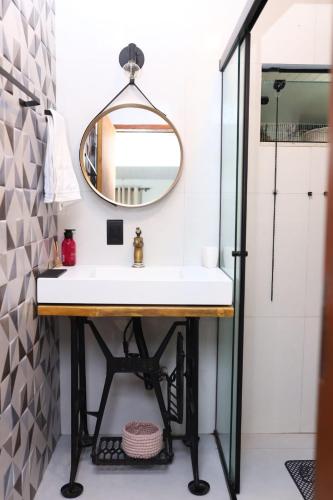 a bathroom with a sink and a mirror at Recanto Hellmann in Gaspar