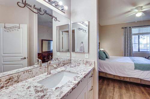 a bathroom with a sink and a bed and a mirror at First-Floor Condo with Pool Access in Mesa! in Mesa