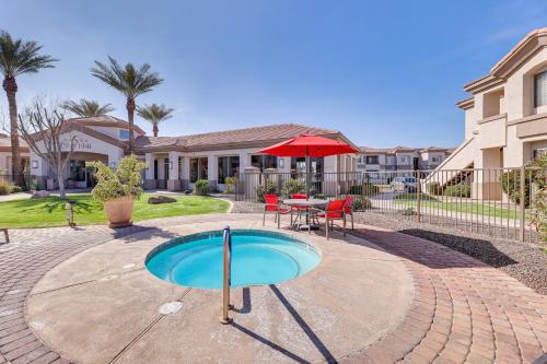 a patio with a table and a red umbrella at First-Floor Condo with Pool Access in Mesa! in Mesa