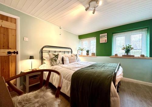 a bedroom with a bed and a green wall at The Bolt in Lynmouth