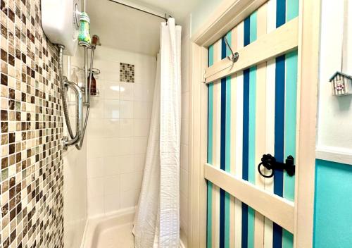 ein Bad mit einer Dusche und einer blauen Tür in der Unterkunft The Bolt in Lynmouth
