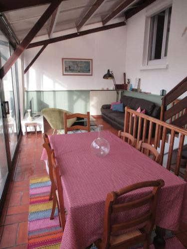 un salon avec une table et un chiffon de table violet dans l'établissement Maison à Cholet à 20 minutes du Puy du Fou, à Cholet
