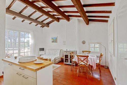 une cuisine et un salon avec une table et des chaises dans l'établissement Le Mas des Oliviers - Welkeys, à La Croix-Valmer