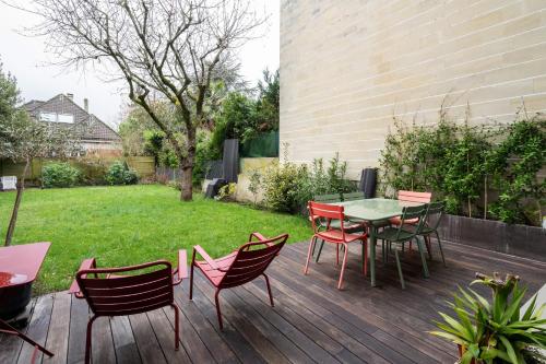 a patio with a table and chairs on a deck at Large villa with garden in Suresnes - Welkeys in Suresnes