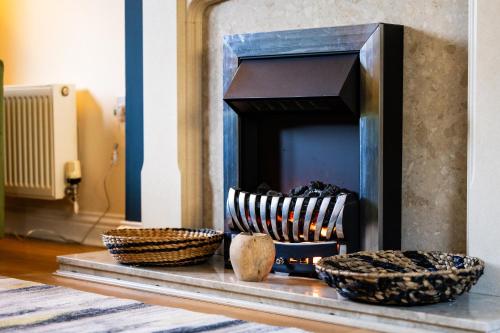 a fireplace with three bowls on a table at Maxwell Gardens in Huntingdon