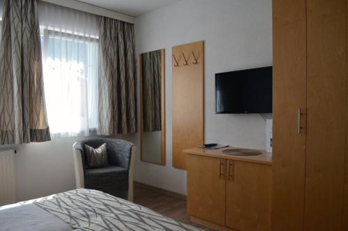 Una habitación de hotel con una cama y un televisor. en Apart Anna, en Ischgl