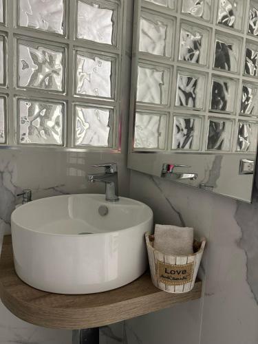 a bathroom with a white sink and two windows at B&B IL PICCOLO PRINCIPE in Mercato San Severino