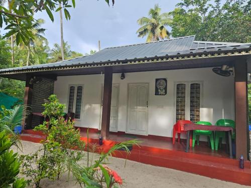 una pequeña casa con una mesa roja delante en Marari Aleena Home stay, en Mararikulam