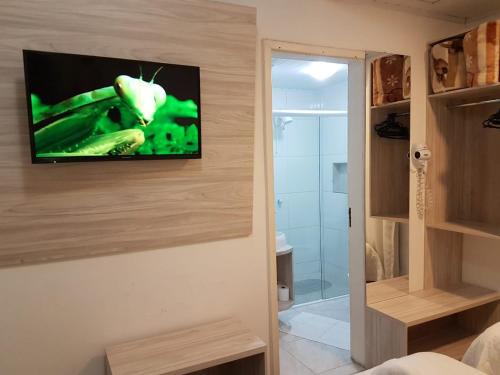 a room with a television on a wall with a bathroom at Lages Plaza Hotel in Lages