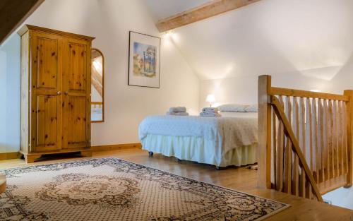Schlafzimmer mit einem Bett und einem Holzschrank in der Unterkunft Arc de Anges/Angel's Arch in Cussay