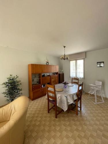 un salon avec une table et des chaises dans l'établissement Location maison saisonnière, à Pleurtuit