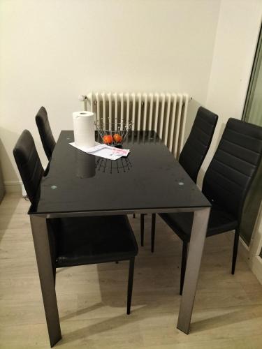 une table à manger noire avec des chaises noires et un radiateur dans l'établissement Keva apartment, à Tours