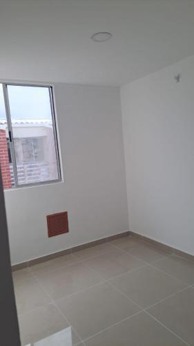 Apartamento في بارانكويلا: غرفة بجدار أبيض ونافذة