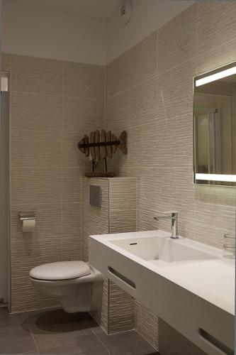 a bathroom with a sink and a toilet and a tub at The Originals Hôtel Le Cise Restaurant Chambres et Suites in Ault