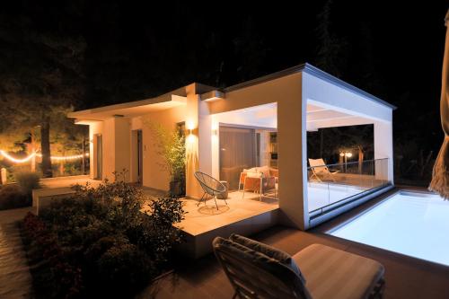 a small house with a patio at night at 4RosesVillas in Litochoro