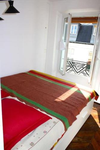 un lit dans une chambre avec une fenêtre dans l'établissement Beautiful 1 bedroom in Le Marais, à Paris