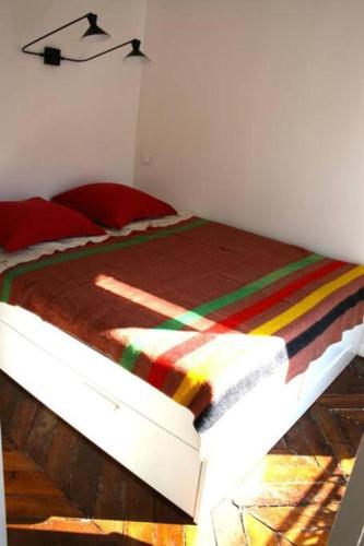- une chambre avec un lit et une couverture colorée dans l'établissement Beautiful 1 bedroom in Le Marais, à Paris