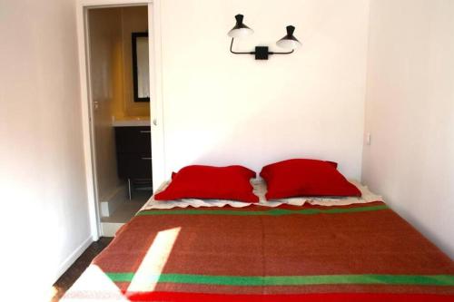 een slaapkamer met een bed met 2 rode kussens bij Beautiful 1 bedroom in Le Marais in Parijs