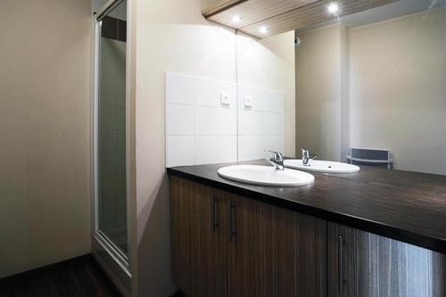uma casa de banho com 2 lavatórios e um espelho em Résidence Serias - 3 Pièces pour 6 Personnes 534 em Germ