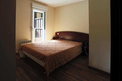 Schlafzimmer mit einem Bett und einem Fenster in der Unterkunft Résidence Serias - 3 Pièces pour 6 Personnes 544 in Germ