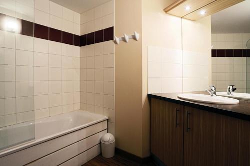 ein Badezimmer mit einer Badewanne und einem Waschbecken in der Unterkunft Résidence Serias - 3 Pièces pour 6 Personnes 544 in Germ