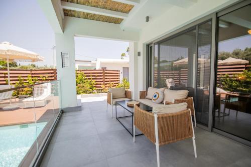 a patio with a table and chairs and a pool at 4RosesVillas in Litochoro